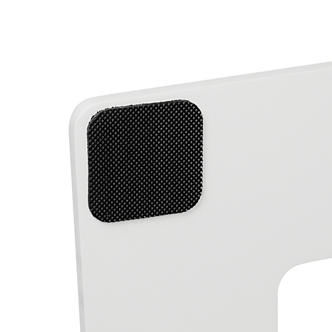 Nahaufnahme eines schwarzen, strukturierten Anti-Rutsch-Pads auf einer glatten, weißen Oberfläche.