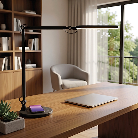 Moderne schwarze Schreibtischlampe auf einem Holztisch mit Laptop und Smartphone.