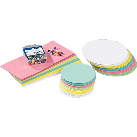 Colorful stacks of paper and round cards next to push pins and a box with small balls.