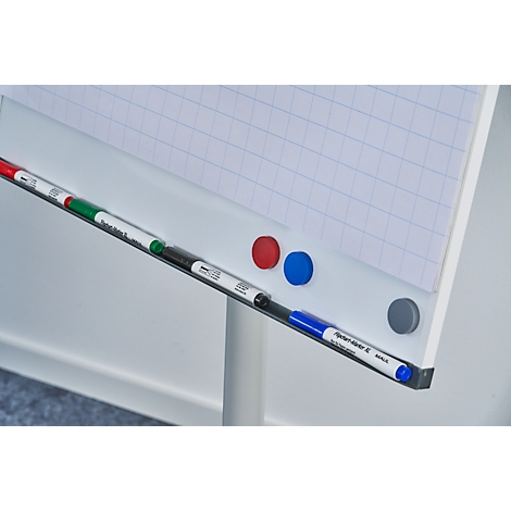 Close-up of a whiteboard with red, green, black and blue markers, next to red, blue and gray magnets.