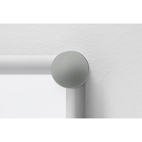 Grey round button on a white bar attached to a white wall.