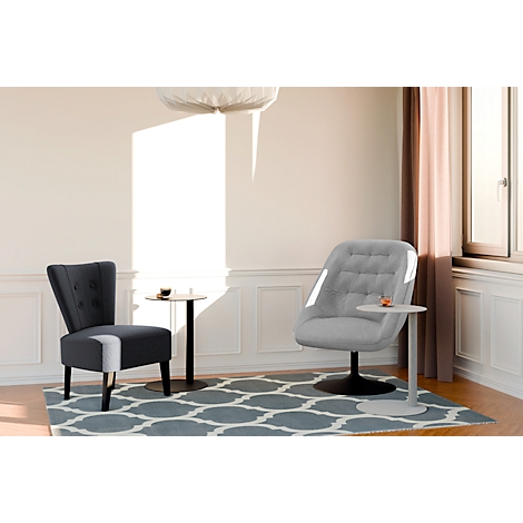 Deux fauteuils avec tables d'appoint sur un tapis. Le fauteuil de droite est gris, celui de gauche est bleu foncé. La lumière du soleil inonde la pièce.