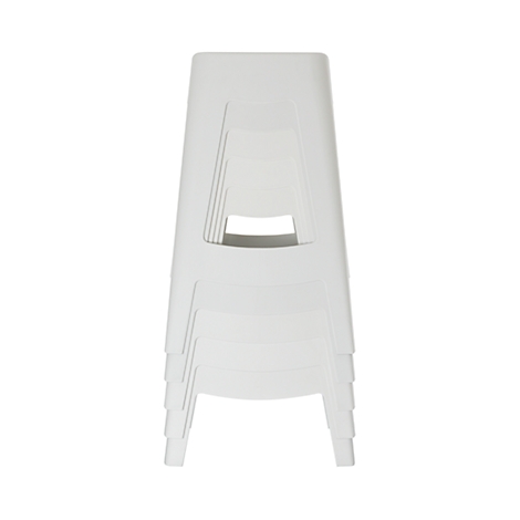 Cinq tabourets en plastique blanc, empilés les uns sur les autres, sur fond blanc.