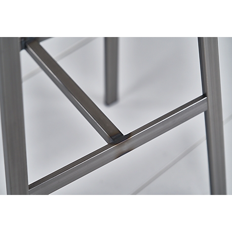 Close-up of a metal stool: Angles of metal struts connected with welds.