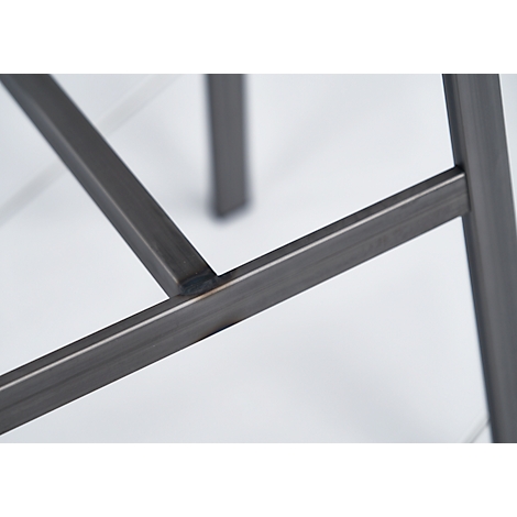 Close-up of the corner joint of a metal frame. Welded, dark grey on a light background.