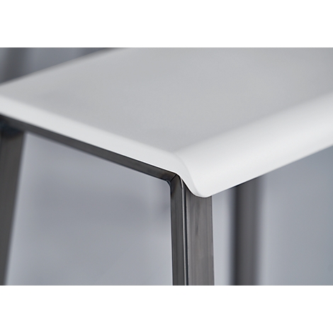 Close-up of a table edge with rounded white surfaces and metal frame. The edge is smooth and modern in design.