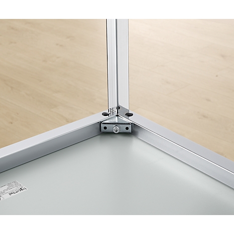 Close-up of a metal corner joint. Three silver metal profiles meet at an angle, reinforced by a bracket.