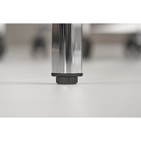 Close-up of a chair leg standing on a white surface. The leg is made of polished metal with a black foot.