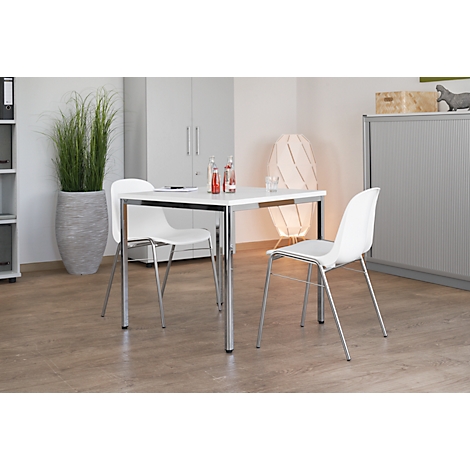 White table and chairs in modern office. A vase with tall ornamental grass in front. Drinks are on the table.
