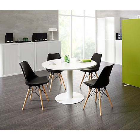 Round white table with four black chairs. Cabinets and a green element in the background.