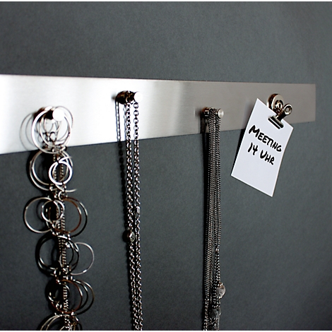 Jewellery and a note that says "Meeting 2 pm" hang on a metal strip.