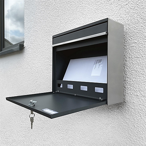 Une boîte aux lettres murale anthracite avec le rabat ouvert et du courrier à l'intérieur. Une clé est accrochée dans la serrure.