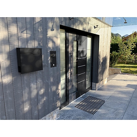Porte d'entrée moderne avec sonnette, boîte aux lettres et paillasson.