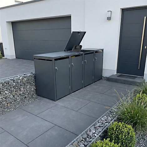 Dunkelgraue Mülltonnenbox vor Haus. Eine Tonne ist geöffnet, daneben Haustür und Garage.