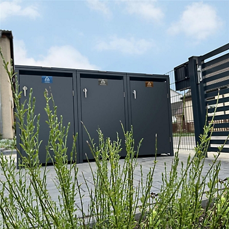 Drie grijze vuilnisbakken buiten. Elke deur heeft een symbool met verschillende kleuren. Op de voorgrond grassen.