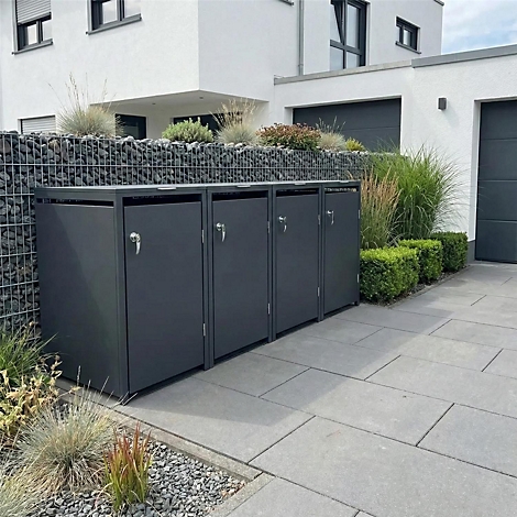 Donkergrijze vuilnisbakken in een geplaveide oprit voor een modern huis.