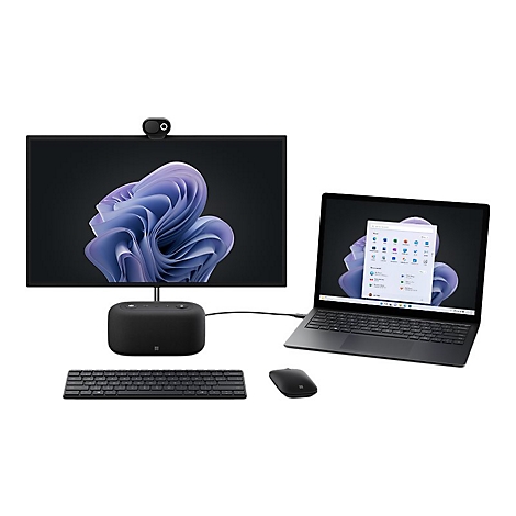 Kompletter Arbeitsplatz mit Laptop, Monitor, Tastatur und Maus. Der Monitor zeigt ein lila Windows-Hintergrundbild.