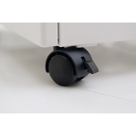 Close-up of a wheel at the bottom of a white cabinet. The wheel is black, with a locking device.