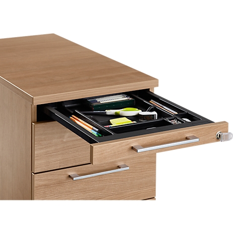 Wooden desk cabinet with open drawer filled with office supplies.