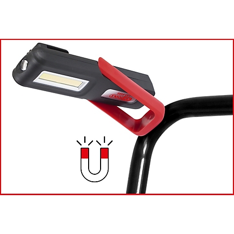 Schwarze Arbeitsleuchte mit roter Halterung, an einem Rohr befestigt, darunter ein Magnetsymbol.
