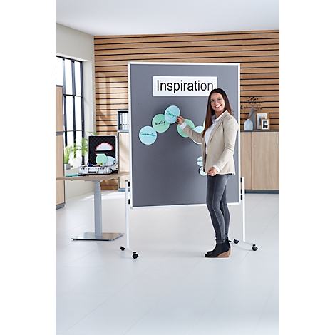 Eine Frau steht vor einer Präsentationstafel mit dem Wort 'Inspiration'. Sie zeigt auf Kreise mit Begriffen wie 'Idee'.