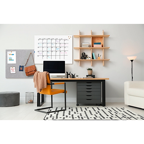 Un espacio de trabajo acogedor con escritorio, calendario, tablón de anuncios y silla. Un ordenador está en el escritorio.