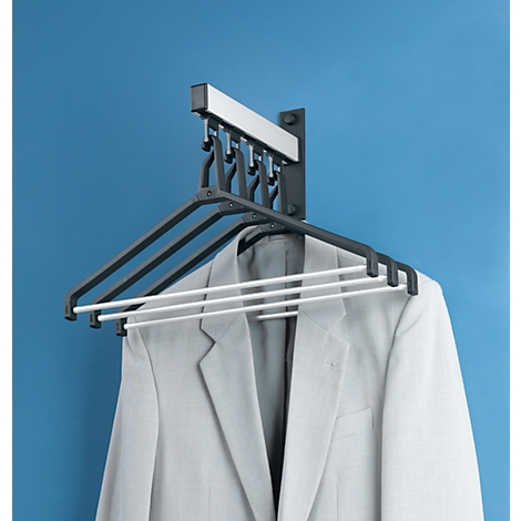 Secadora con chaqueta en pared azul. La secadora tiene varias perchas.