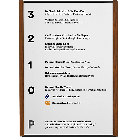 Panneau affichant des cabinets médicaux et des magasins, cadre marron, texte noir sur blanc. Noms, spécialités, numéros de téléphone.