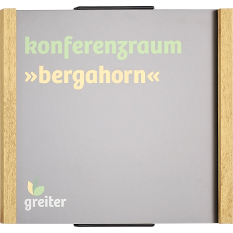 Tableau gris avec cadre en bois, inscription "Konferenzraum »bergahorn«". Le logo de la société greiter est en bas à gauche.