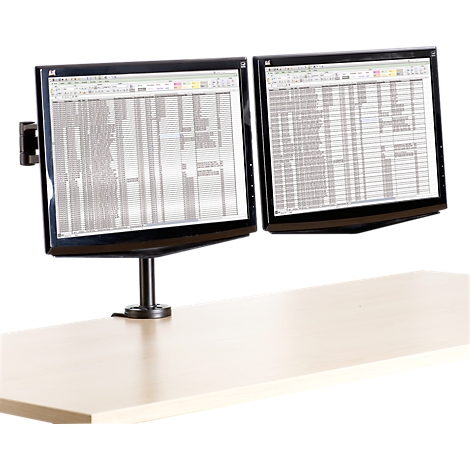 Two monitors on a table, displaying data in a spreadsheet. Black frames, black stand.