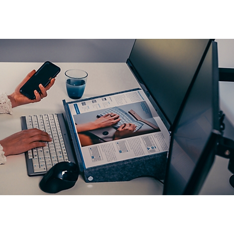 Person am Schreibtisch: Tippen auf Tastatur, Smartphone in Hand, vor Bildschirm, Text-Dokument.