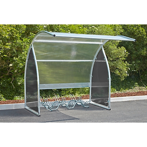 Metal bicycle shelter with transparent roof, against a green background.
