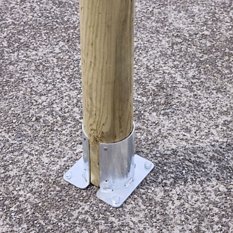 Ein Holzpfosten wird durch eine verzinkte Metallhalterung auf einem gepflasterten Boden befestigt.