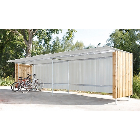 Bicycle shelter with bicycles, wood and corrugated iron roof, outdoors.