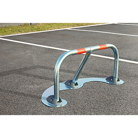 Parking barrier on asphalt, marked in red. It serves as a parking space lock.