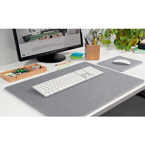 Grey desk set: keyboard, mousepad, pen holder, monitor, pens, sticky notes, and plant. Text on monitor.
