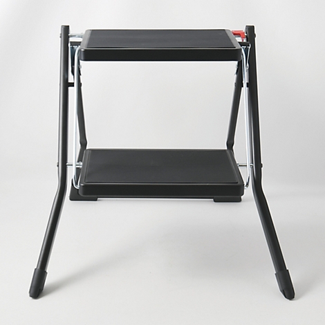 Un tabouret noir à deux marches sur fond blanc.