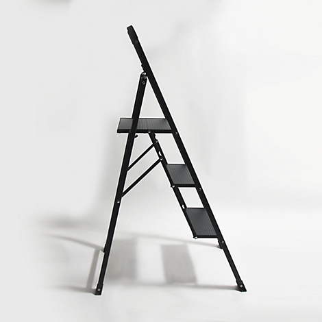 Un escabeau noir est positionné en diagonale sur un fond blanc. Il possède trois marches et un support.