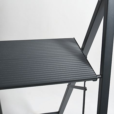 Gros plan d'une plateforme noire et striée d'une structure métallique. Le cadre et les supports sont également noirs.