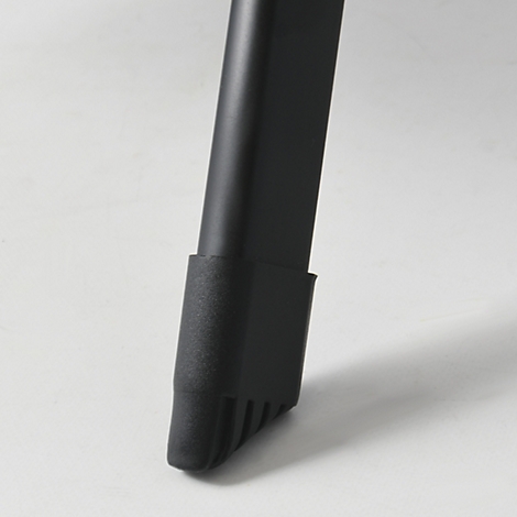 Detailaufnahme eines schwarzen Stuhlbeins mit geriffelter Unterseite auf hellem Hintergrund.