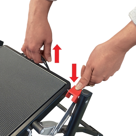 Hände bedienen eine Klappvorrichtung. Rote Pfeile zeigen Richtung. Schwarzer Rahmen, graue Fläche, roter Hebel.