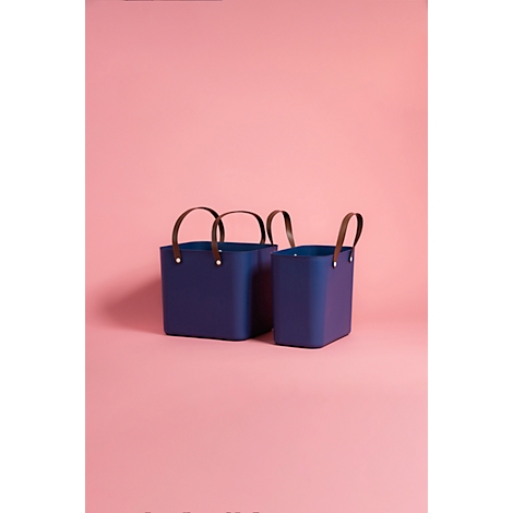 Two blue baskets with brown handles, against a pink background. The basket on the left is larger.