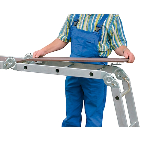 Man in blue overalls holding a brown board over a ladder. The ladder is partially extended.