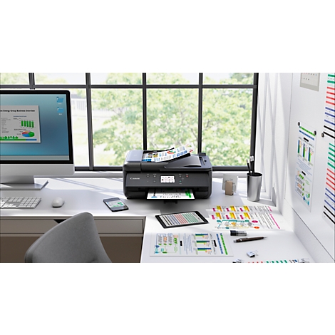 Bureau met printer, monitor, tablet en papieren documenten.