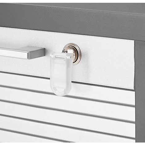 Detailweergave: Een sleutel met een plastic sleutelhanger zit in een slot, naast een eenvoudige zilveren handgreep.