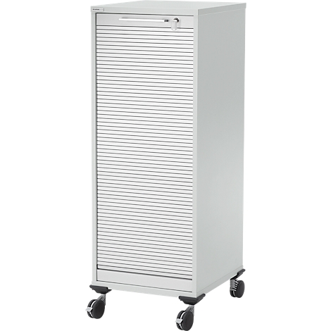 Weißer Schrank mit Rollladen und Rollen. Oben ein Griff und Schloss. Der Schrank steht auf vier Rollen.