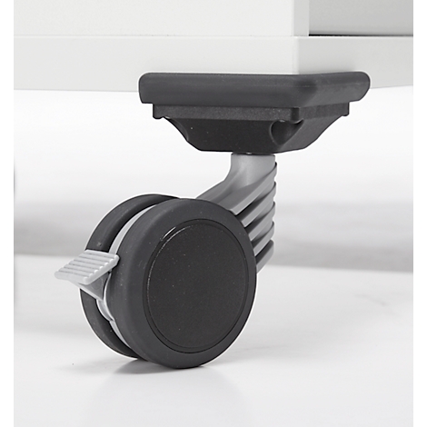 Nahaufnahme eines Rollstuhls mit schwarzem Rad und Bremshebel, unter einem weißen Möbelstück.