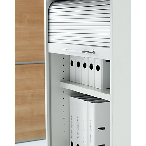 Weißer Rollladenschrank mit Aktenordnern gefüllt.