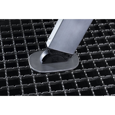 Gros plan d'un pied en métal posé sur une grille en métal. La jambe est argentée, la base du pied est noire.