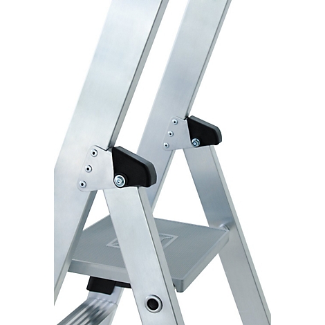 Detail van een trap. Zilveren metalen stutten, zwarte plastic connectoren en een grijze trede.